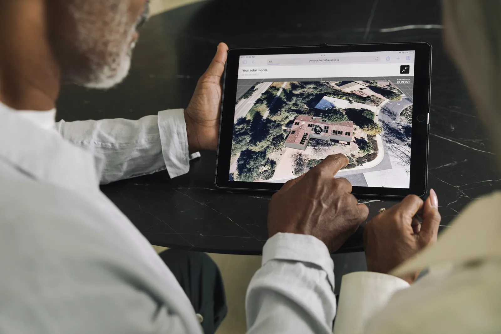 Homeowners reviewing a 3D solar model of their home on a tablet