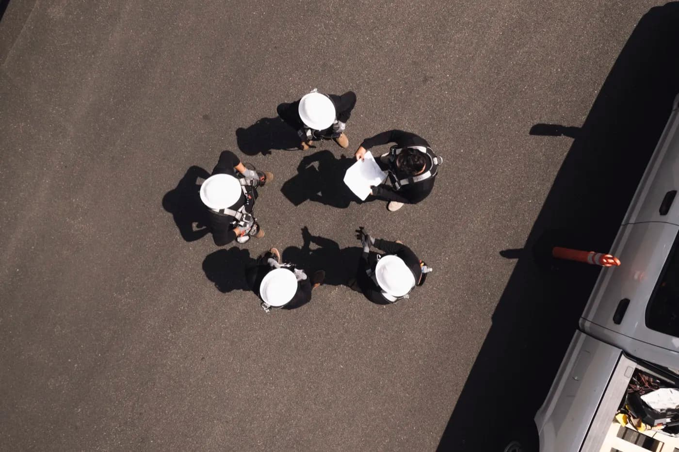 Overhead view of a solar installation crew in hard hats reviewing plans together