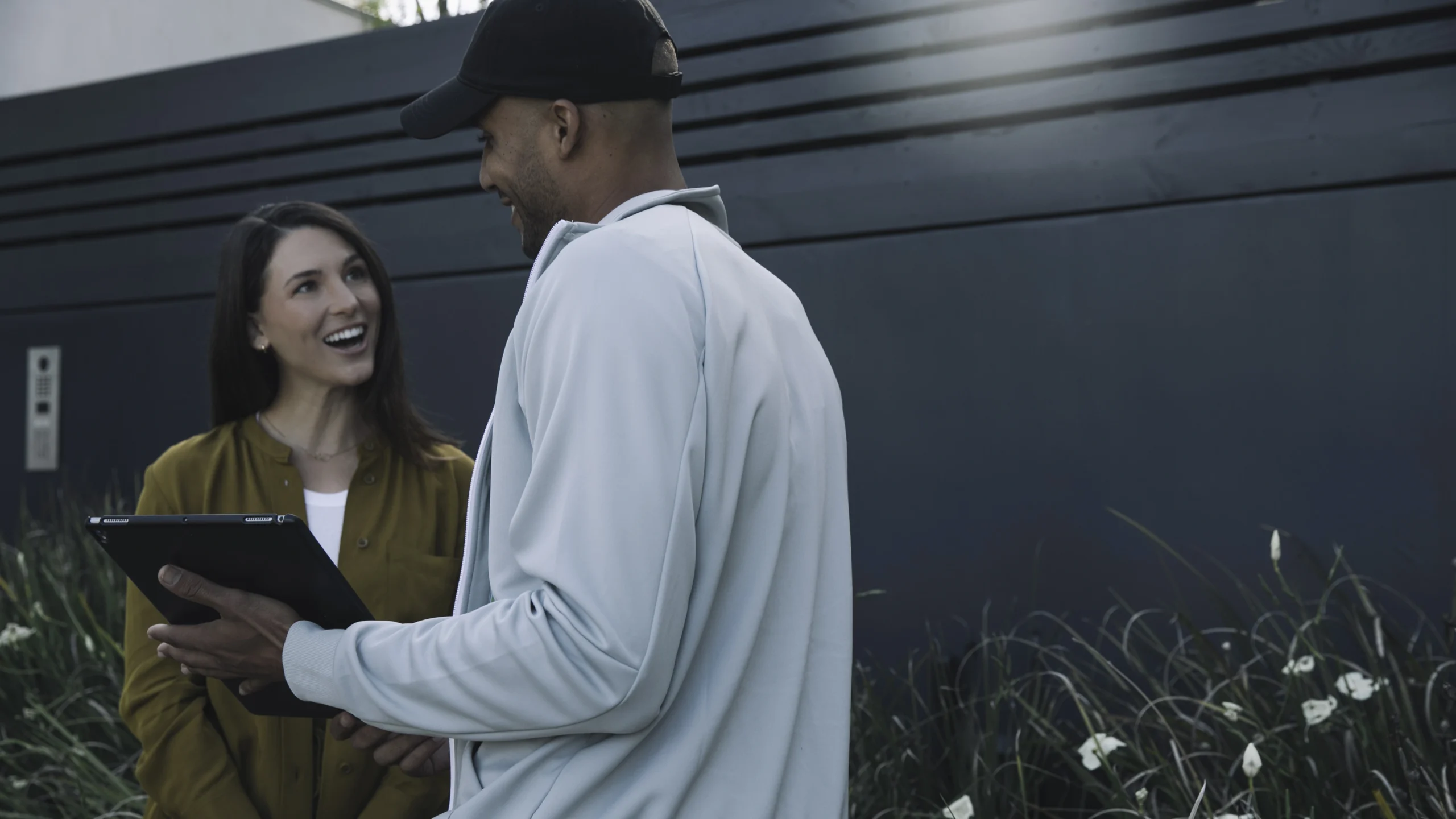 A solar sales person discussing the system design with a homeowner while they're outside.