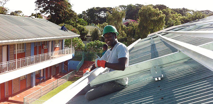 Aurora Solar co-founder Sam Adeyemo installs solar on a school in Africa